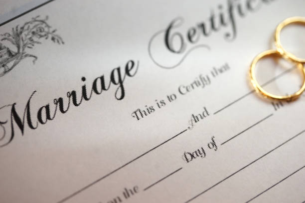 Imagen den certificado de matrimonio y dos anillos.