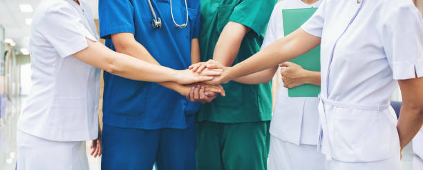 Equipo de profesionales de salud juntándoselos sus manos.