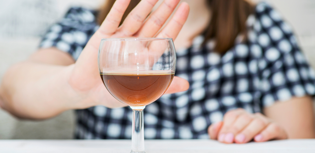 Imagen de una mujer rechazando una copa de vino