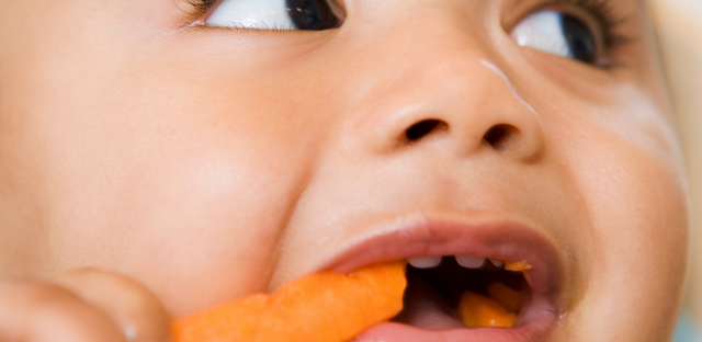 Niño comiendo zanahoria.