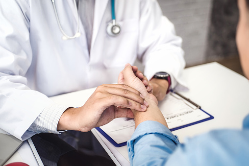 Imagen de doctor evaluando el pulso de su paciente.